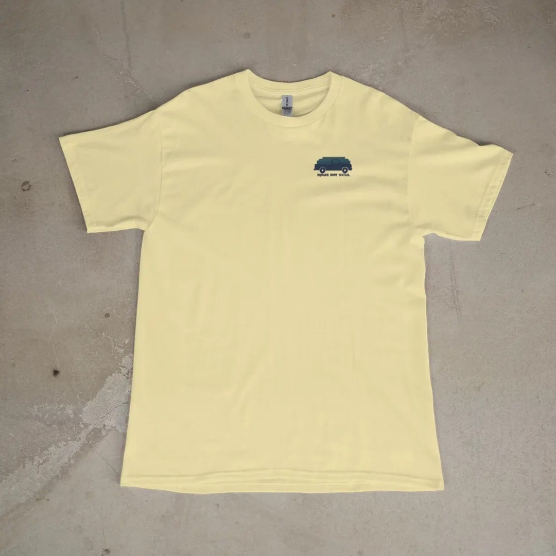 Front of a Butter tee laid flat, with the small Square Body Social logo on the left chest.