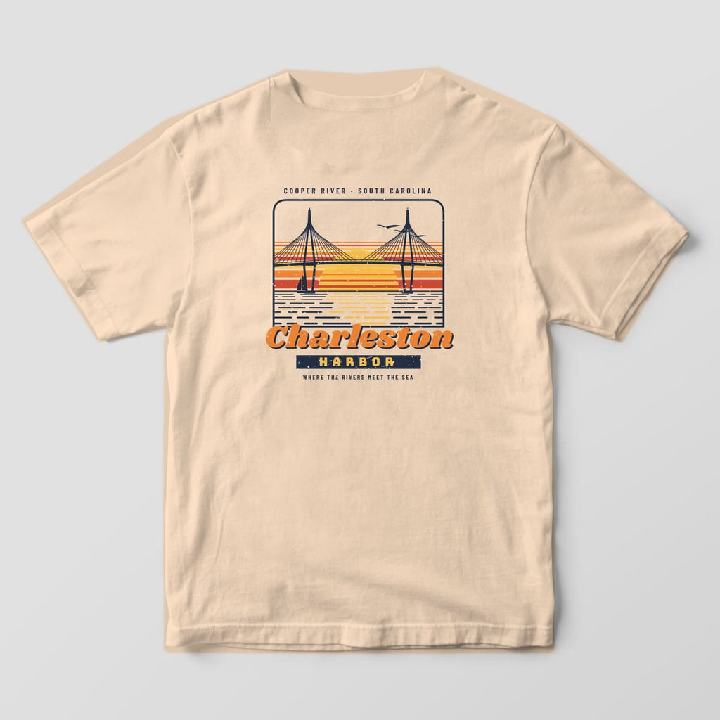 Back of an Ivory Comfort Colors 1717 tee with a hand-drawn cable-stayed bridge over a red, orange and gold striped sunset above the words Charleston Harbor.