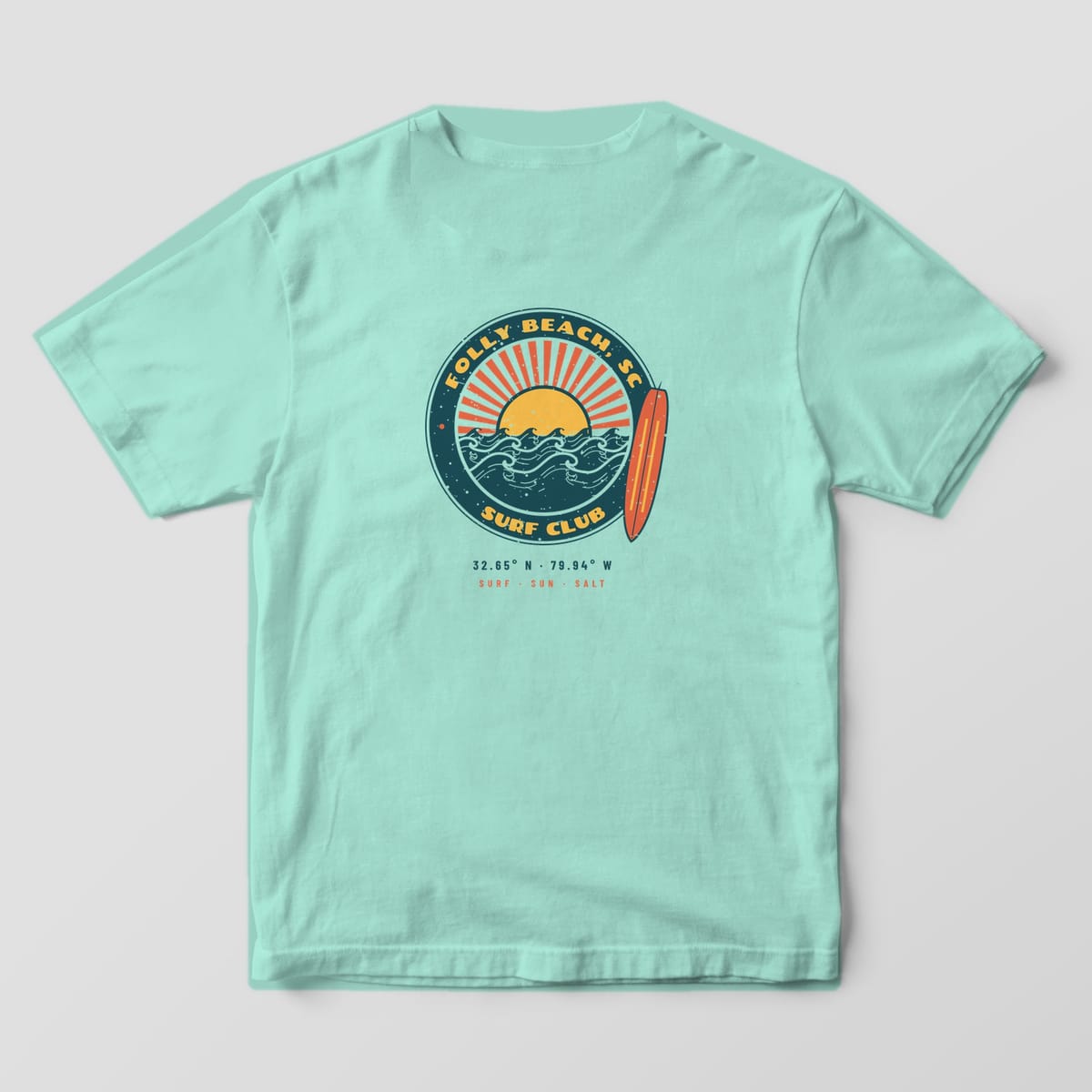 Back of a Chalky Mint Comfort Colors 1717 tee with a teal, coral and yellow surf badge reading Folly Beach, SC and Surf Club, with a longboard breaking the frame.