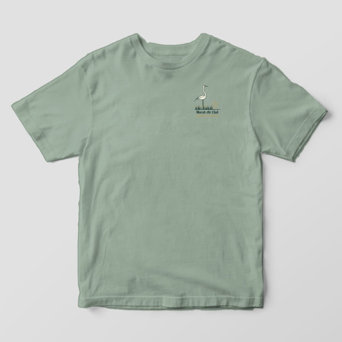 Front of a Bay Comfort Colors 1717 tee with a small left-chest egret standing in marsh grass above the words Marsh Air Club, Low Tide Is a Lifestyle.