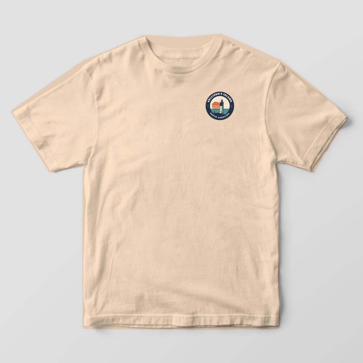 Front of a Ivory Comfort Colors 1717 tee with a small left-chest Sullivan's Island South Carolina lighthouse badge.