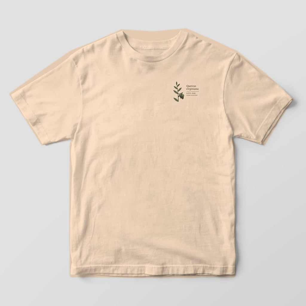 Front of a Ivory Comfort Colors 1717 tee with a small left-chest live oak sprig with acorns and the words Quercus virginiana.