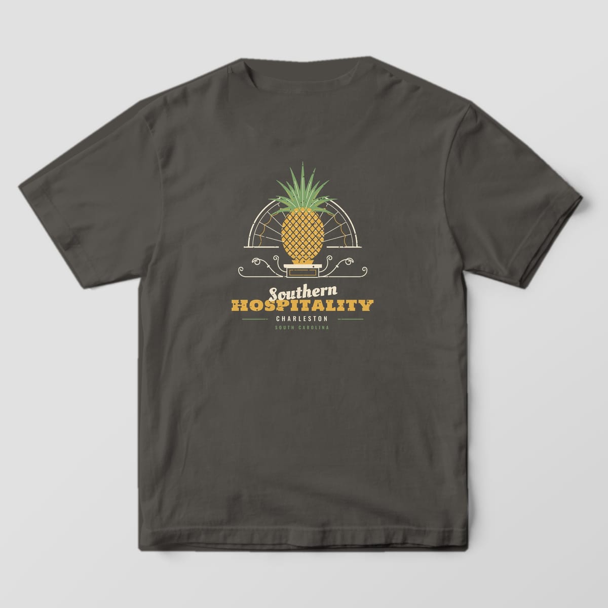 Back of a Pepper Comfort Colors 1717 tee with a gold and green pineapple in front of a cream fanlight arch above the words Southern Hospitality, Charleston.