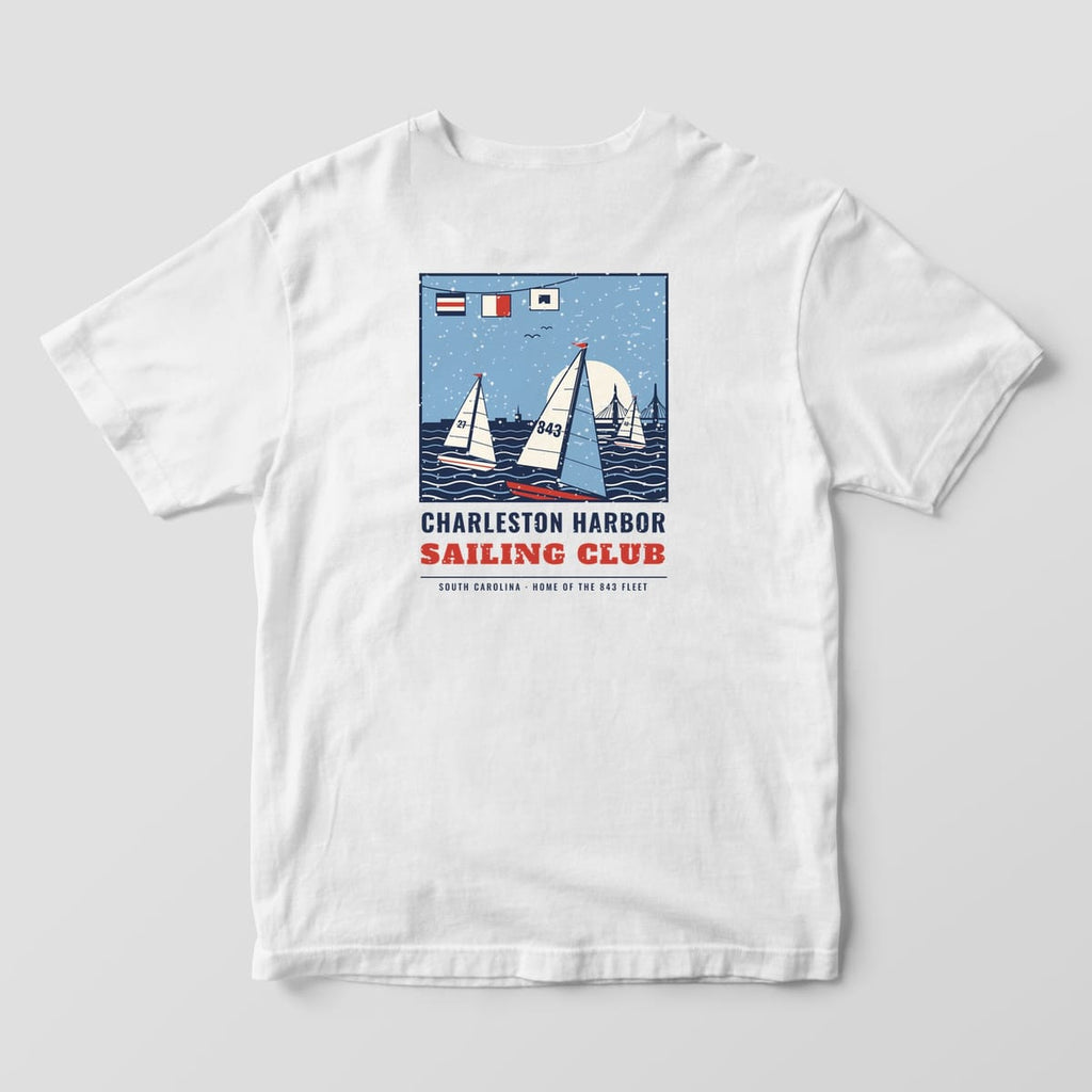 Back of a White Comfort Colors 1717 tee with a navy, red and sky blue poster of three sailboats racing at sunset above the words Charleston Harbor Sailing Club.