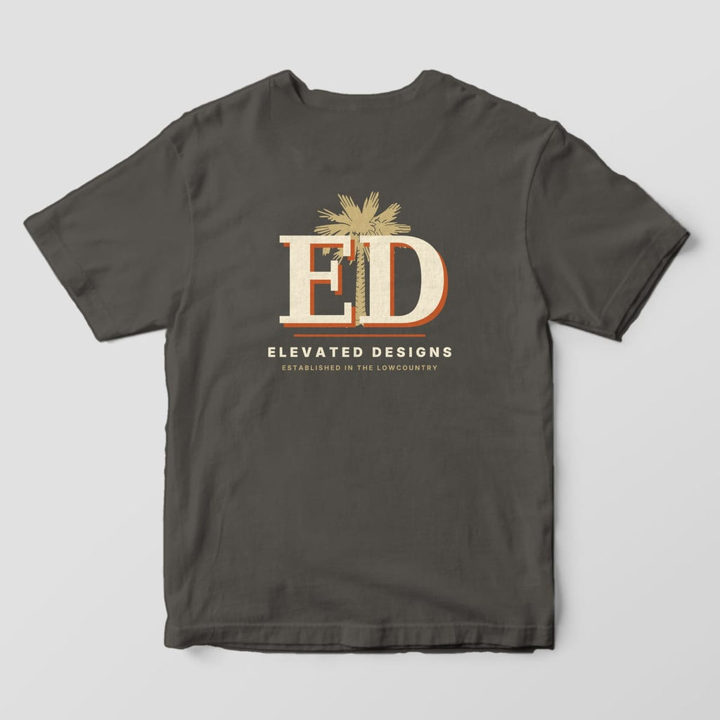 Back of a Pepper Comfort Colors 1717 tee with a large cream-and-rust ED monogram with a tan palmetto tree behind it, then ELEVATED DESIGNS and ESTABLISHED IN THE LOWCOUNTRY.
