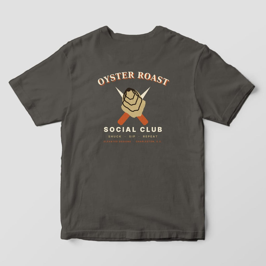 Back of a Pepper Comfort Colors 1717 tee with OYSTER ROAST arched over a tan oyster shell and crossed rust-handled shucking knives, with SOCIAL CLUB and SHUCK · SIP · REPEAT below.