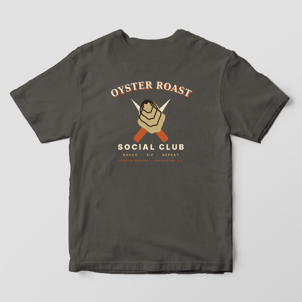 Back of a Pepper Comfort Colors 1717 tee with OYSTER ROAST arched over a tan oyster shell and crossed rust-handled shucking knives, with SOCIAL CLUB and SHUCK · SIP · REPEAT below.