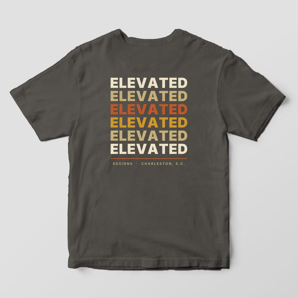 Back of a Pepper Comfort Colors 1717 tee with the word ELEVATED stacked six times in cream, tan, rust, gold, tan and cream, with a rust line and DESIGNS · CHARLESTON, S.C.