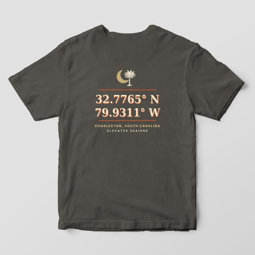 Back of a Pepper Comfort Colors 1717 tee with a gold crescent moon and palmetto above the coordinates 32.7765° N 79.9311° W in cream and rust, then CHARLESTON, SOUTH CAROLINA.