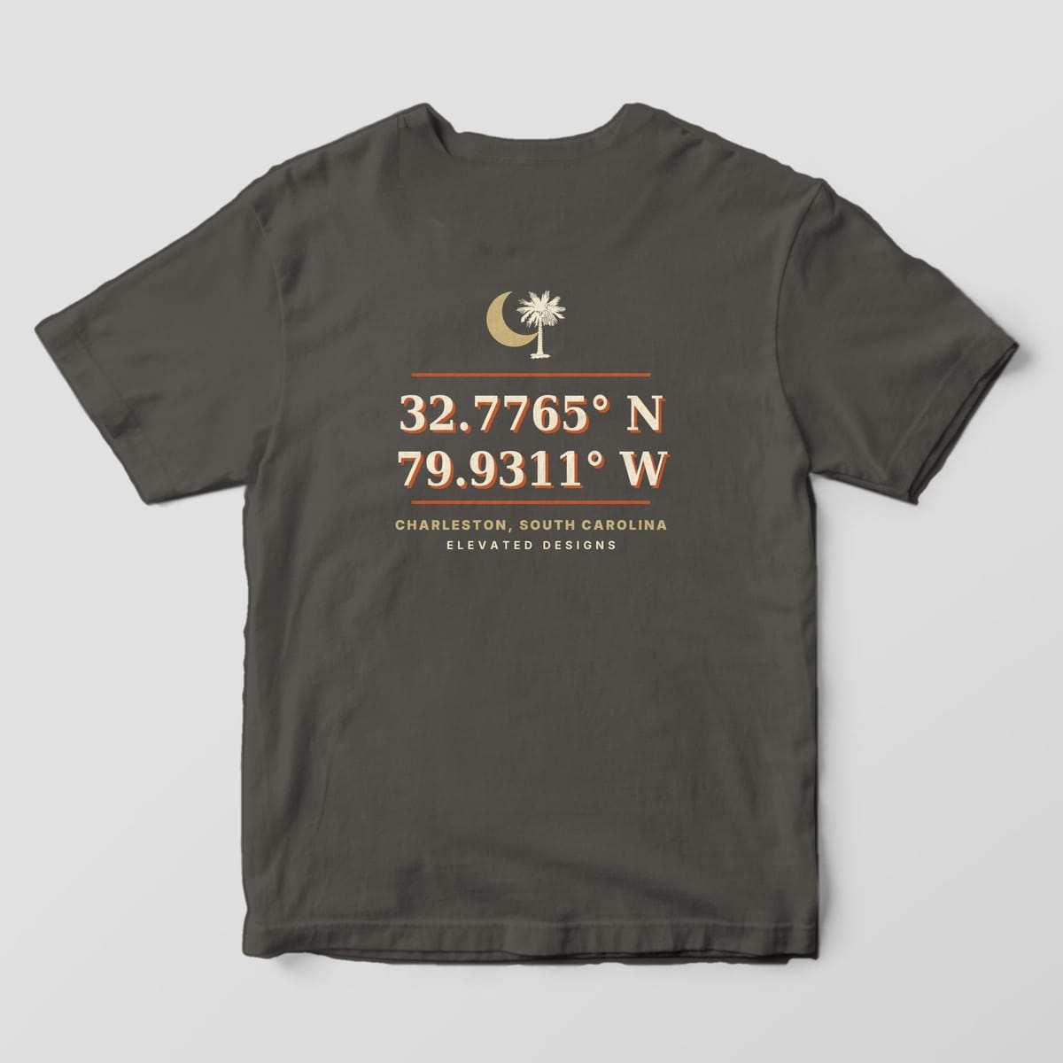 Back of a Pepper Comfort Colors 1717 tee with a gold crescent moon and palmetto above the coordinates 32.7765° N 79.9311° W in cream and rust, then CHARLESTON, SOUTH CAROLINA.