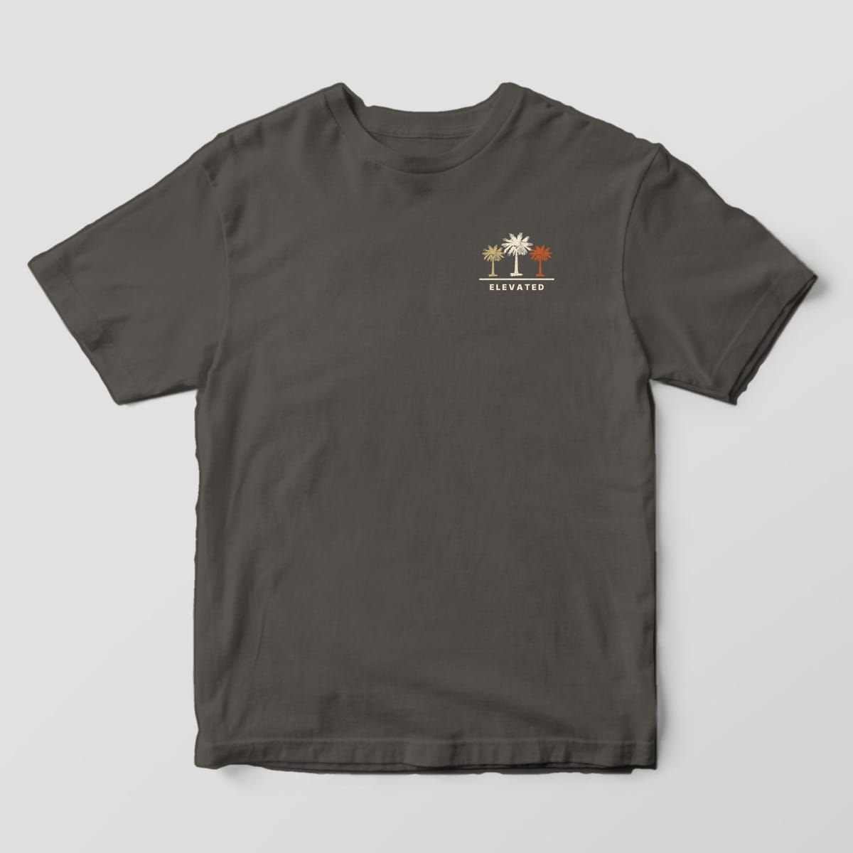 Front of a Pepper Comfort Colors 1717 tee with a small left-chest row of three palmettos in tan, cream and rust above the word ELEVATED.
