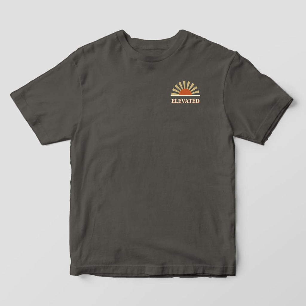 Front of a Pepper Comfort Colors 1717 tee with a small left-chest rust half-sun with tan rays above the word ELEVATED.