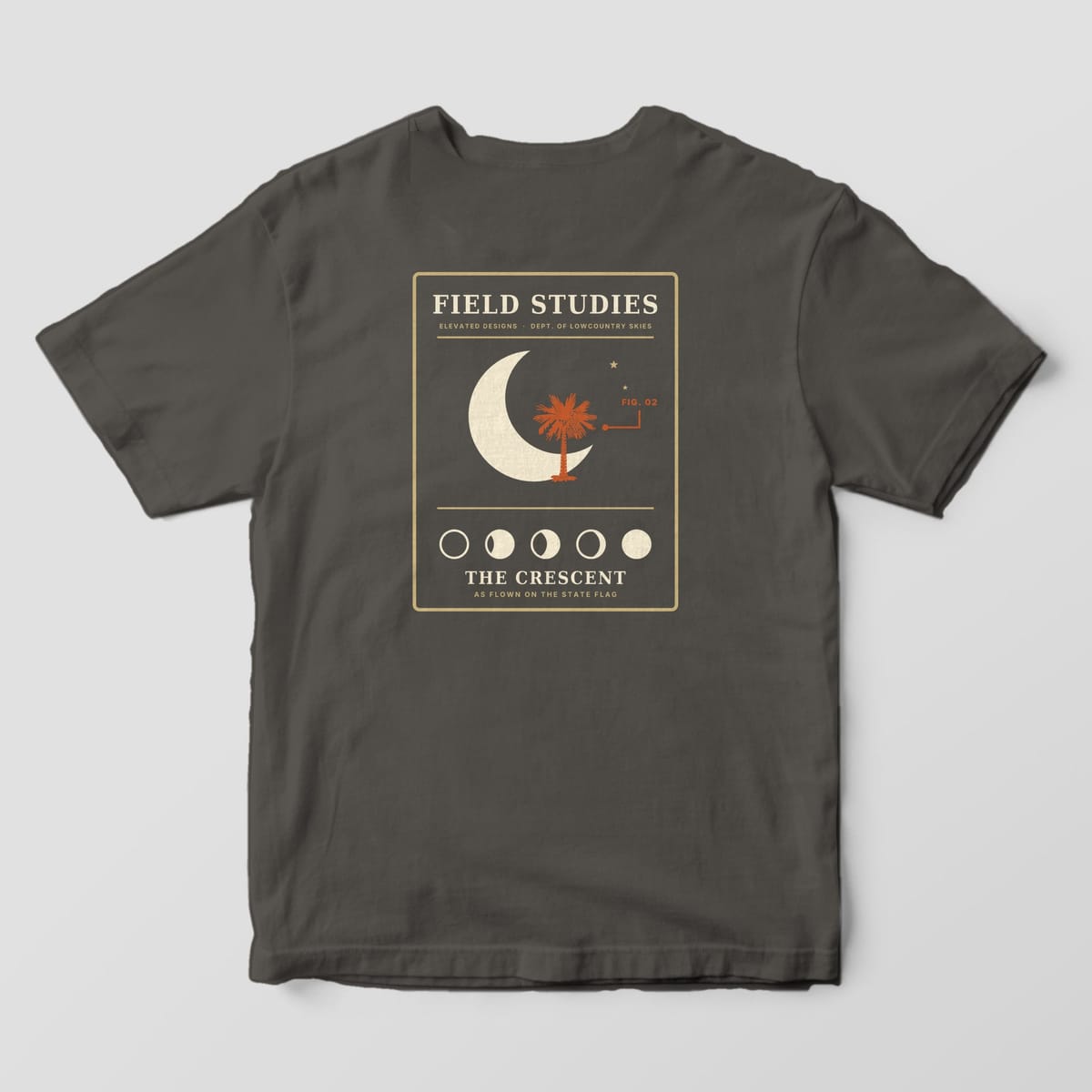 Back of a Pepper Comfort Colors 1717 tee with a tan-outlined Field Studies card with a cream crescent moon, a rust palmetto, a FIG. 02 callout, five moon phases and THE CRESCENT, AS FLOWN ON THE STATE FLAG.