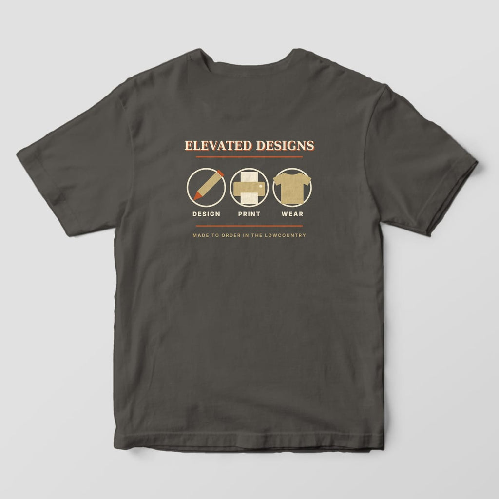 Back of a Pepper Comfort Colors 1717 tee with ELEVATED DESIGNS over three circled tan icons, a pencil, a printer and a t-shirt, labeled DESIGN, PRINT and WEAR, with MADE TO ORDER IN THE LOWCOUNTRY.