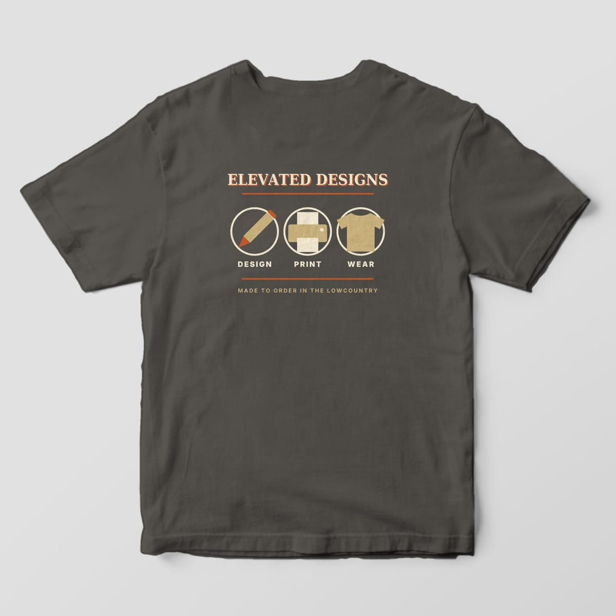 Back of a Pepper Comfort Colors 1717 tee with ELEVATED DESIGNS over three circled tan icons, a pencil, a printer and a t-shirt, labeled DESIGN, PRINT and WEAR, with MADE TO ORDER IN THE LOWCOUNTRY.