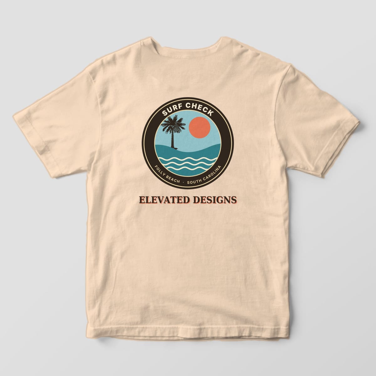 Back of an Ivory Comfort Colors 1717 tee with a round SURF CHECK badge reading FOLLY BEACH · SOUTH CAROLINA with a palmetto, coral sun and teal waves, above ELEVATED DESIGNS.