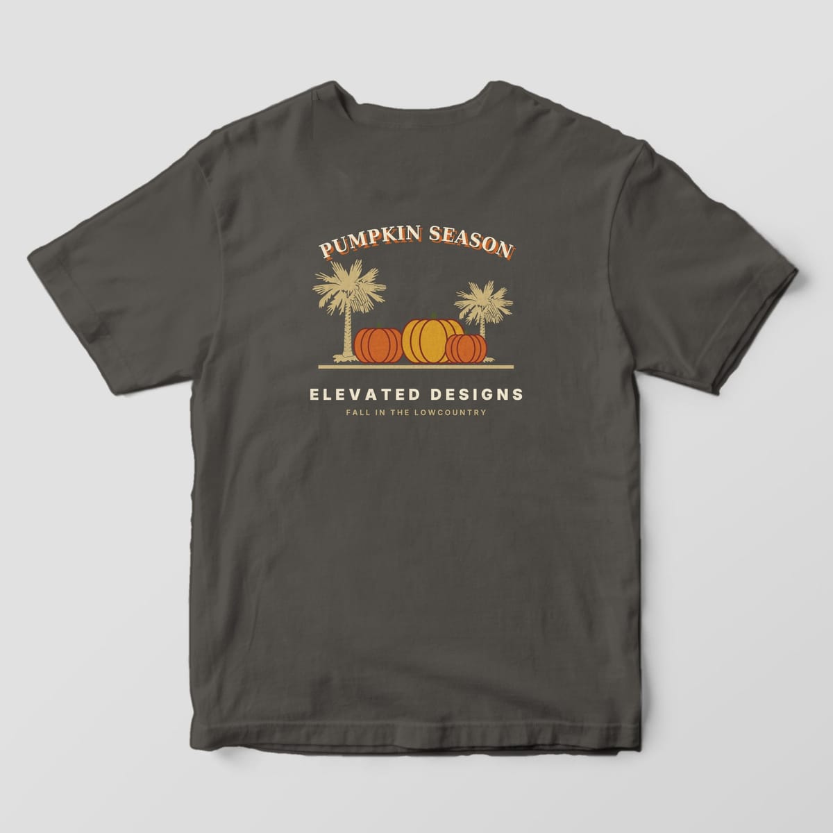 Back of a Pepper Comfort Colors 1717 tee with PUMPKIN SEASON arched over three orange and gold pumpkins between two tan palmetto trees, above ELEVATED DESIGNS and FALL IN THE LOWCOUNTRY.