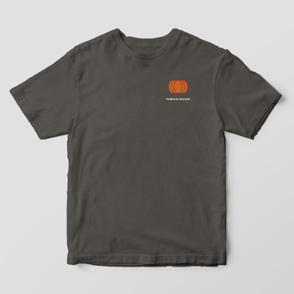 Front of a Pepper Comfort Colors 1717 tee with a small left-chest orange pumpkin with a green stem above PUMPKIN SEASON.