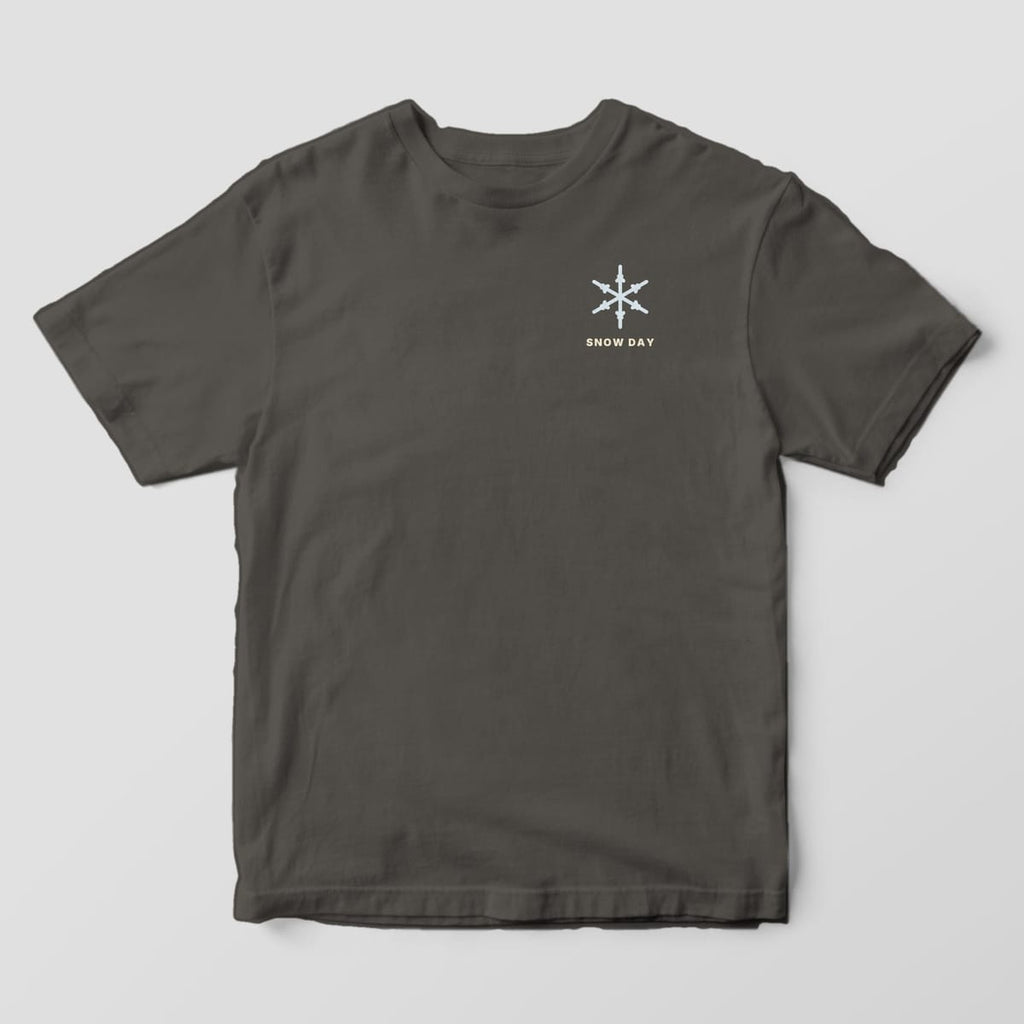 Front of a Pepper Comfort Colors 1717 tee with a small left-chest pale blue snowflake above the words SNOW DAY.