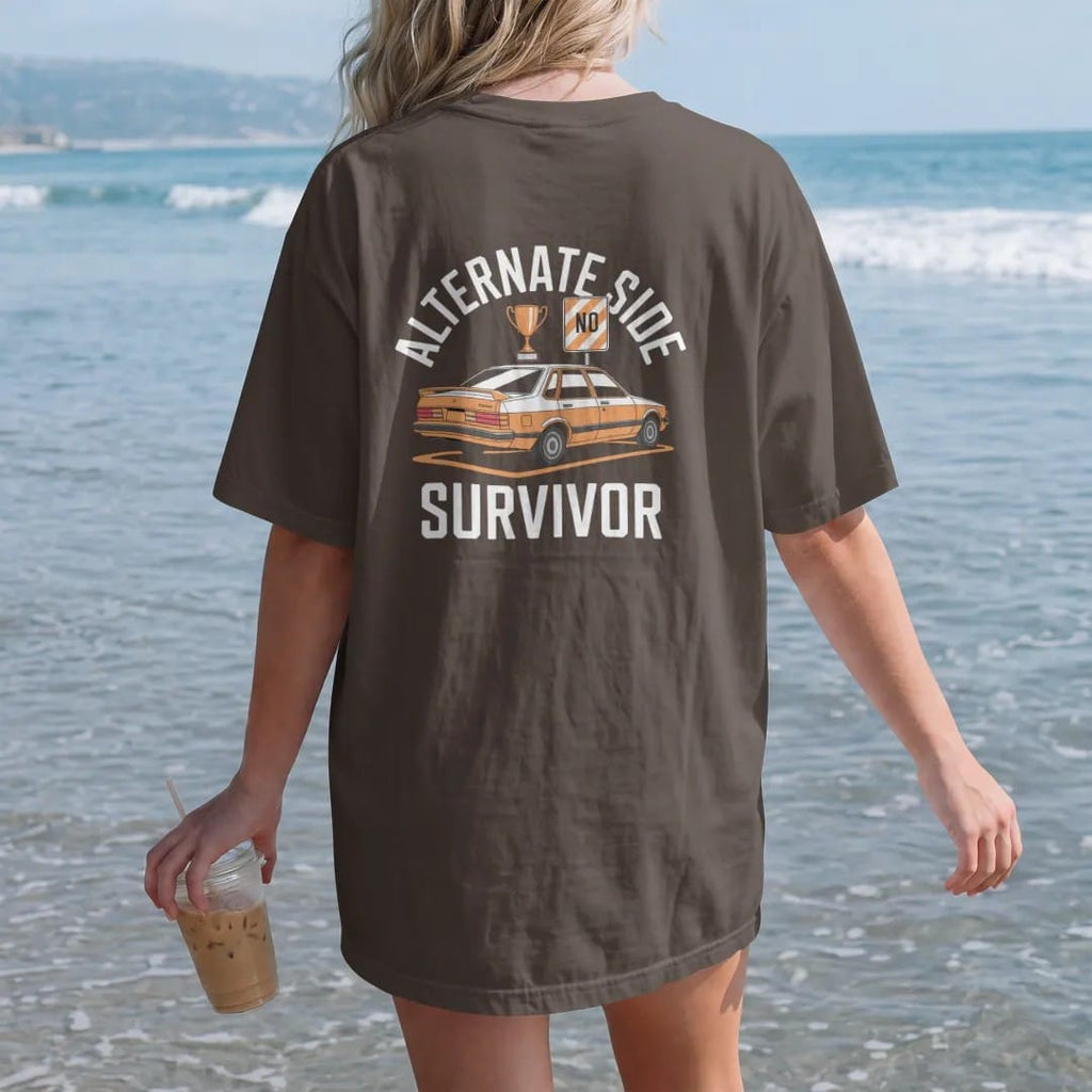 Woman on the beach in a Espresso tee, back view: a dented sedan with a trophy on the roof beside a no-parking sign under Alternate Side and over Survivor, in bone white, orange, yellow and green.