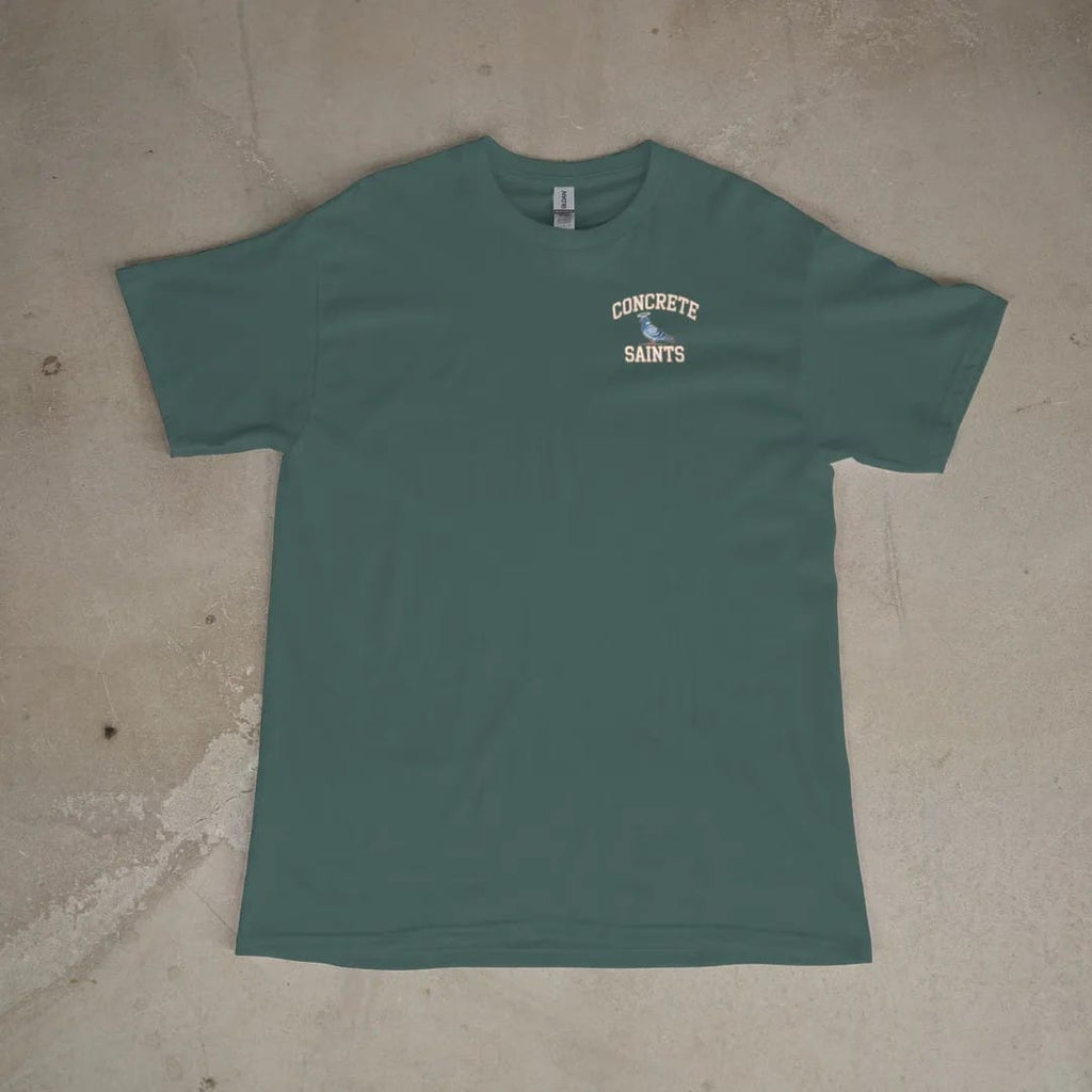 Front of a Blue Spruce tee laid flat, with the small Concrete Saints logo on the left chest.