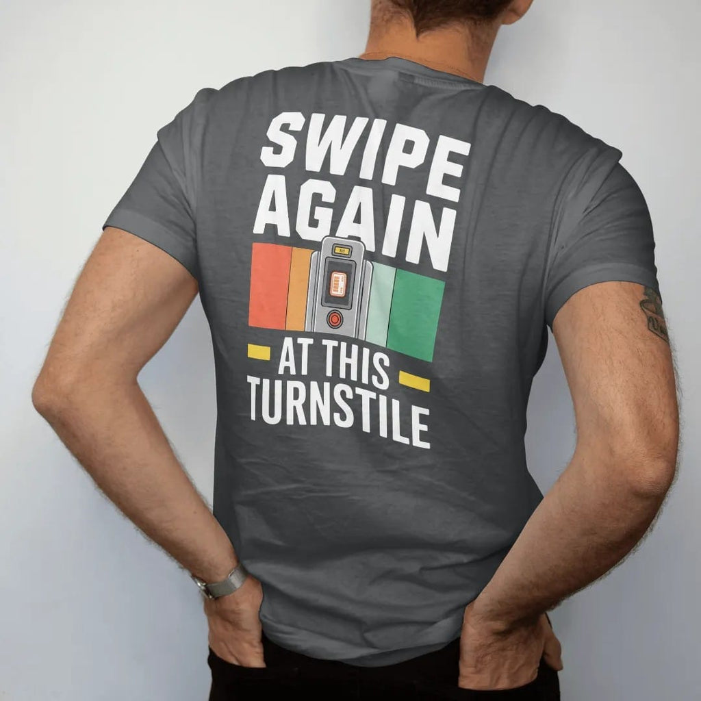 Man wearing a Graphite tee, seen from the back: a subway turnstile with a fare card mid-swipe and an error screen reading Swipe Again At This Turnstile, in yellow, green, orange and bone white.