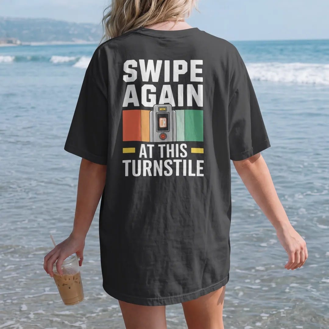 Woman on the beach in a Black tee, back view: a subway turnstile with a fare card mid-swipe and an error screen reading Swipe Again At This Turnstile, in yellow, green, orange and bone white.