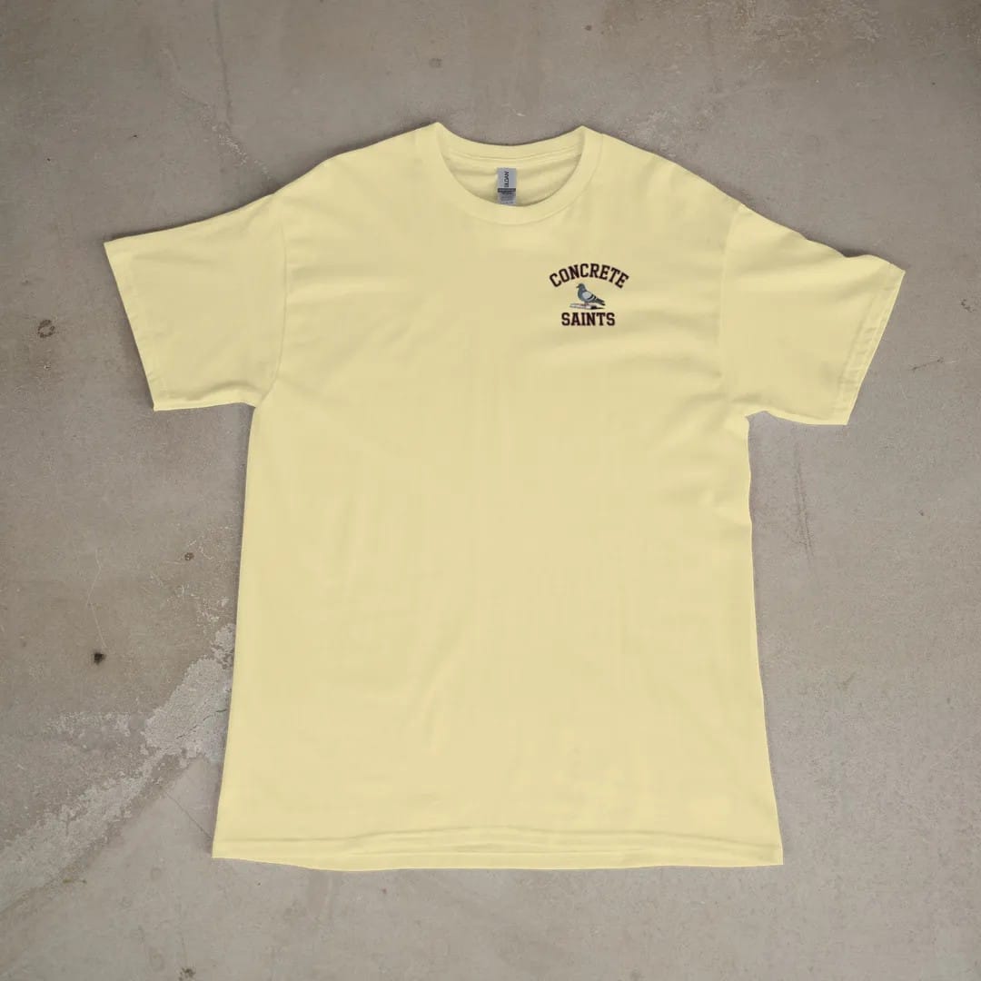 Front of a Butter tee laid flat, with the small Concrete Saints logo on the left chest.