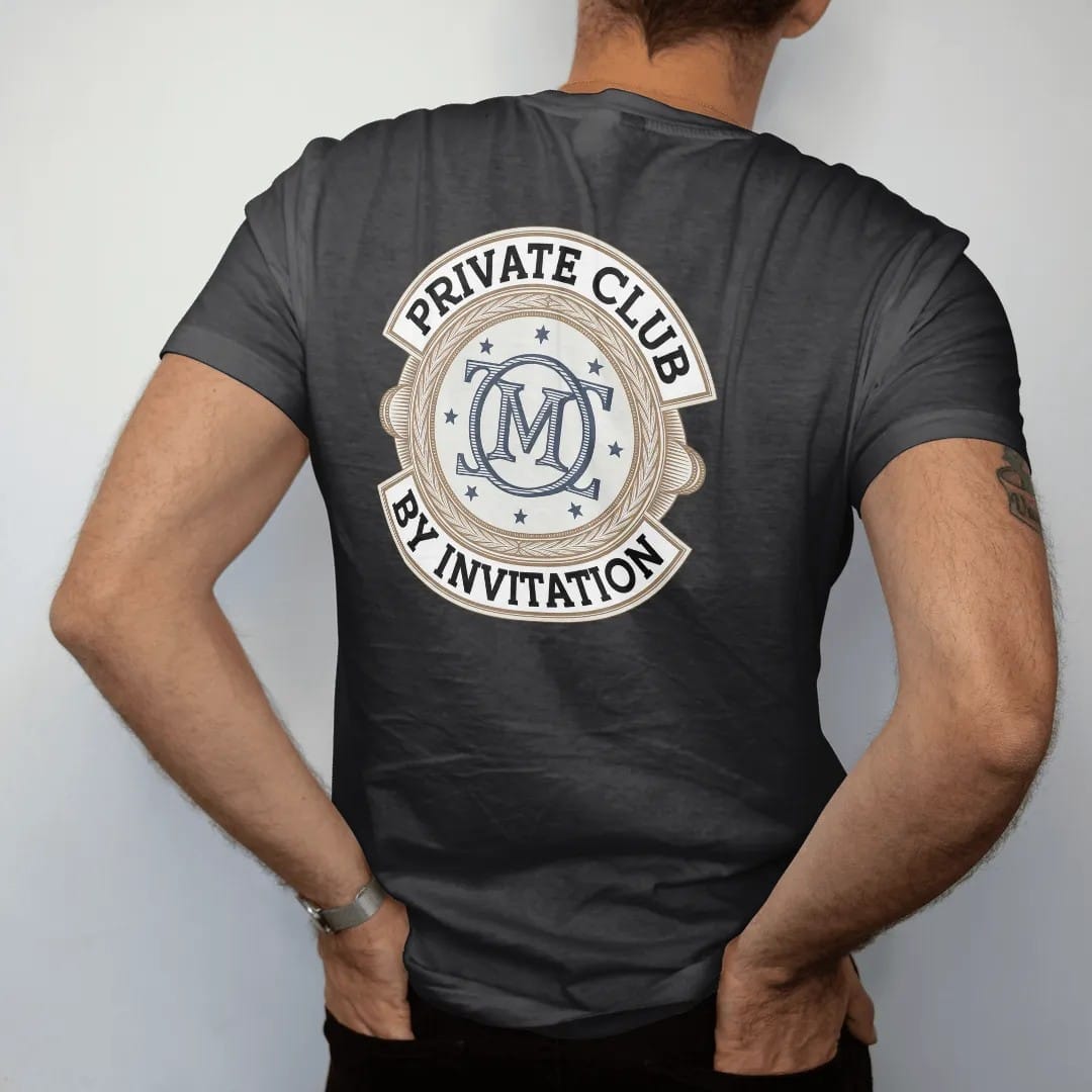 Man wearing a Black tee, seen from the back: an interlocking serif monogram in a double ring with tiny stars, ringed by Private Club and By Invitation, as a fine engraving in navy and antique gold.