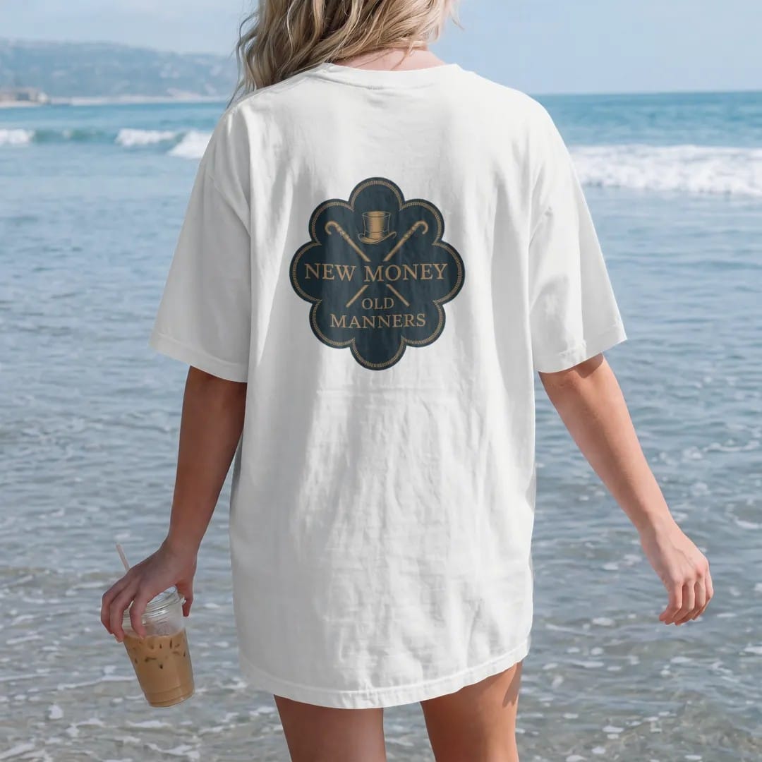 Woman on the beach in a White tee, back view: a small top hat and crossed cane between New Money and Old Manners, as a fine engraving in navy and antique gold.