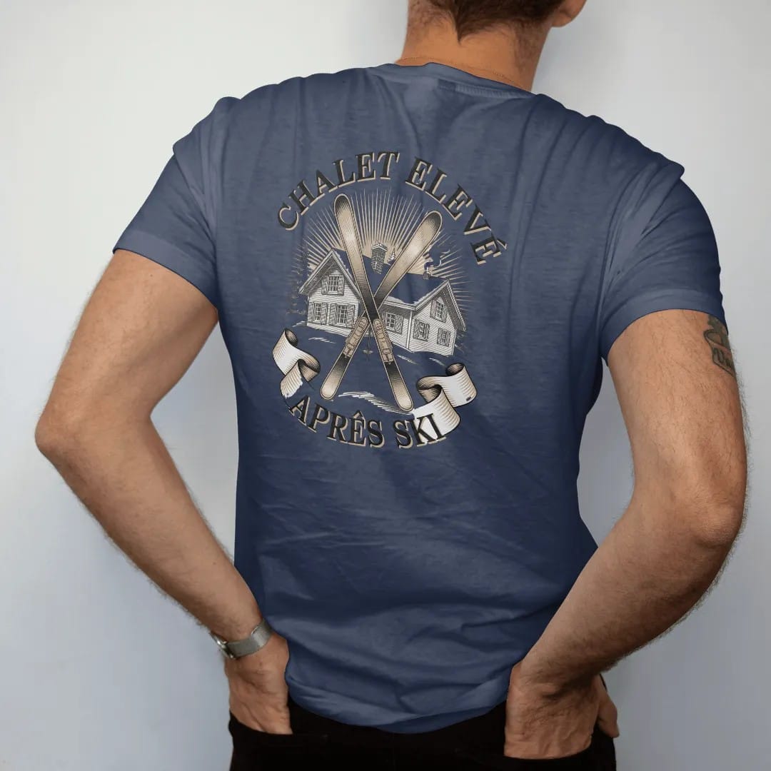 Man wearing a Navy tee, seen from the back: a snowy alpine chalet with crossed vintage skis and pines under Chalet Elevé and an Après Ski banner, as a fine engraving in cream and champagne gold.