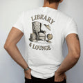 Man wearing a White tee, seen from the back: a leather armchair with books, a brass lamp and a globe under Library and & Lounge, as a fine engraving in cream and champagne gold.