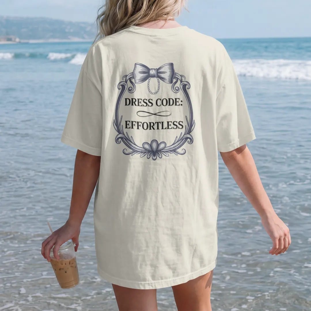Woman on the beach in a Ivory tee, back view: an invitation-style layout with a bow tie and pearl strand, Dress Code: in spaced caps over a large Effortless script, as a fine engraving in navy and antique gold.