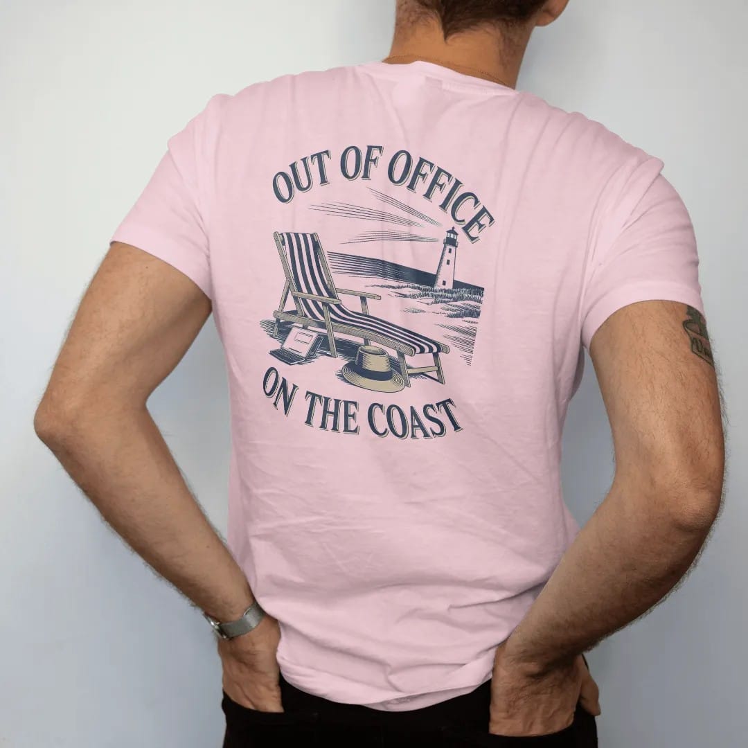 Man wearing a Blossom tee, seen from the back: a striped lounge chair, straw hat and closed laptop on a beach with a lighthouse, under Out Of Office and On The Coast, as a fine engraving in navy and antique gold.