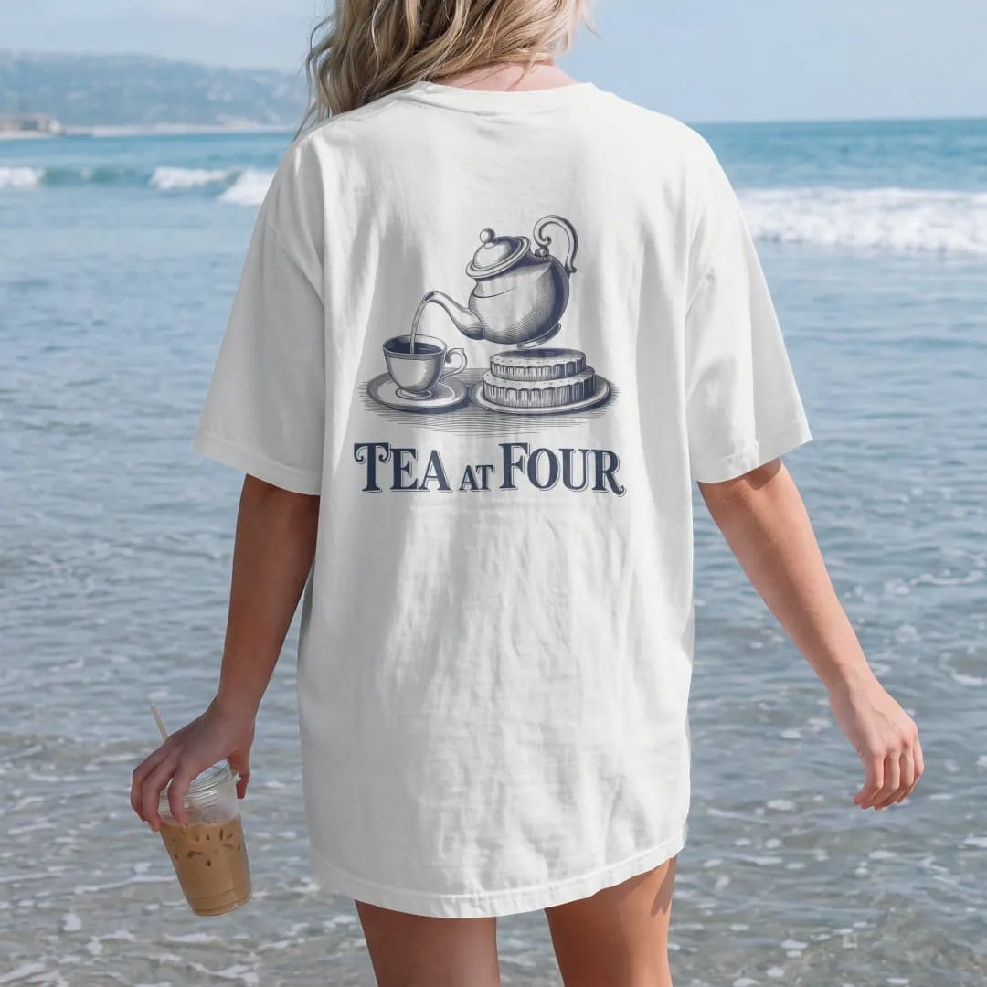 Woman on the beach in a White tee, back view: a porcelain teapot pouring into a cup beside a tiered cake tray with Tea At Four, as a fine engraving in navy and antique gold.