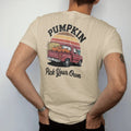 Man wearing a Sandstone tee, seen from the back: an old pickup truck bed loaded with pumpkins beside hay and corn stalks, with "PUMPKIN PATCH" and "PICK YOUR OWN" in chunky 70s lettering and brush script, printed in faded, cracked brown, rust red,…