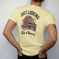 Man wearing a Butter tee, seen from the back: a cluttered antique booth with a rocking chair, old radio and oil lamp, with "JUST LOOKING" and "(FOR 4 HOURS)" in chunky 70s lettering and brush script, printed in faded, cracked brown, rust red,…