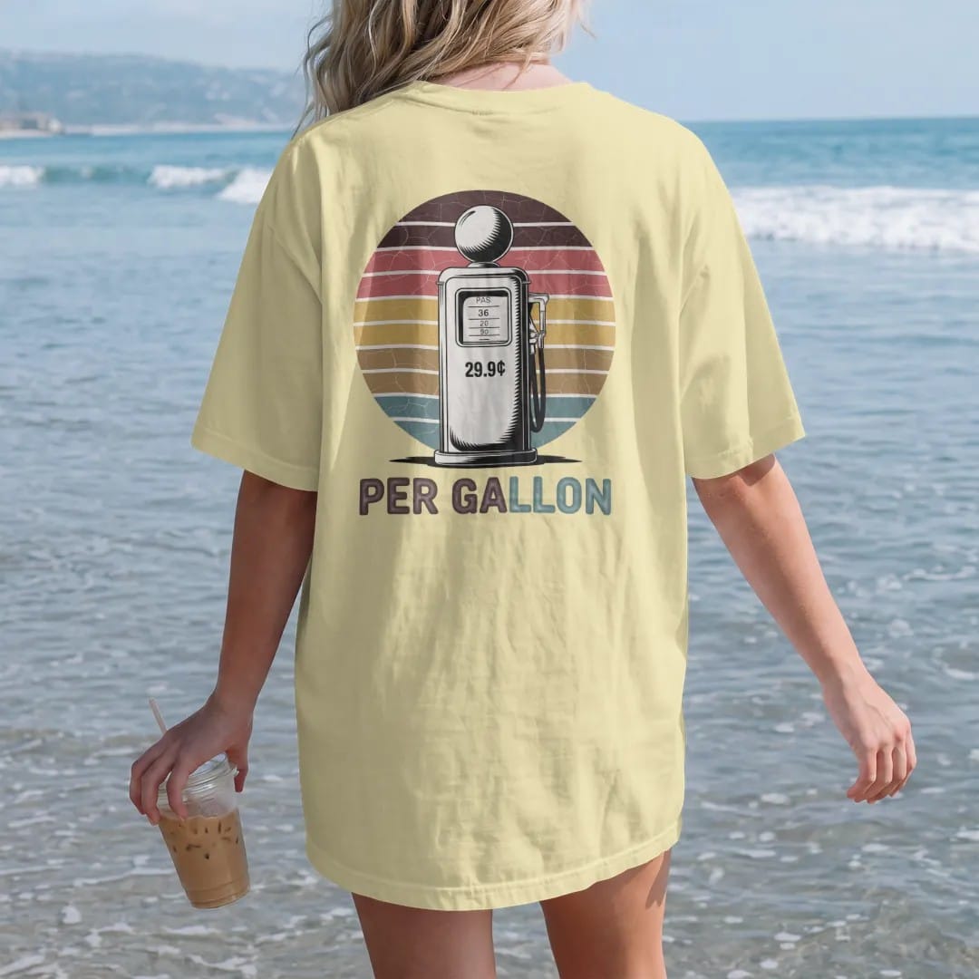 Woman on the beach in a Butter tee, back view: a tall vintage gas pump with a globe and a rolling price window, with "29.9¢" and "PER GALLON" in chunky 70s lettering and small 70s caps, printed in faded, cracked brown, rust red, mustard and dusty…