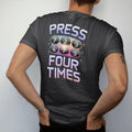 Man wearing a Black tee, seen from the back: a chunky phone keypad with the seven key glowing, with "PRESS 7" and "FOUR TIMES" in liquid-chrome bubble letters and small pixel type, printed in glossy gunmetal chrome, cobalt, hot magenta and violet…