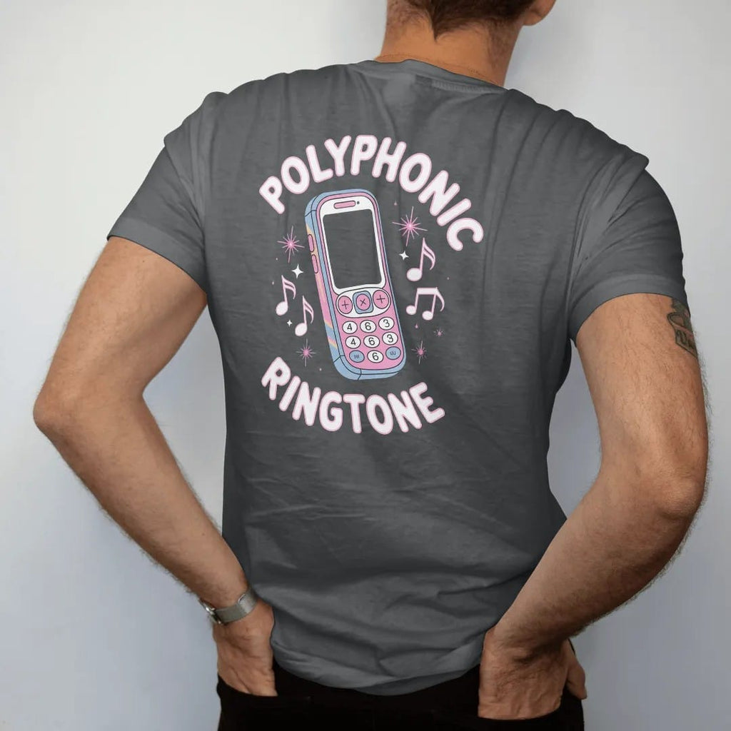 Man wearing a Graphite tee, seen from the back: a candy-bar cell phone ringing with pixel music notes, with "POLYPHONIC" and "RINGTONE" in liquid-chrome bubble letters and small pixel type, printed in glossy chrome silver, baby blue, bubblegum pink…
