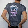 Man wearing a Midnight tee, seen from the back: a CRT monitor showing a starfield screensaver, with "SCREENSAVER" and "MODE" in liquid-chrome bubble letters and small pixel type, printed in glossy chrome silver, baby blue, bubblegum pink and violet…