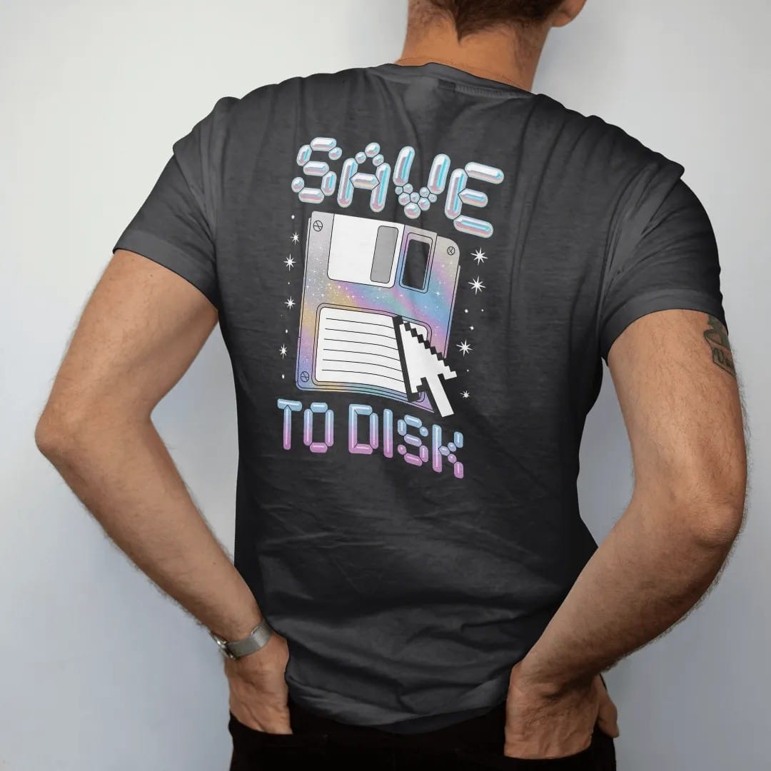 Man wearing a Black tee, seen from the back: an oversized floppy disk with a pixel cursor clicking it, with "SAVE" and "TO DISK" in liquid-chrome bubble letters and small pixel type, printed in glossy gunmetal chrome, cobalt, hot magenta and violet…