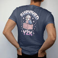 Man wearing a Navy tee, seen from the back: a cartoon computer bug in a hard hat on a beige tower, with "SURVIVED" and "Y2K" in liquid-chrome bubble letters and small pixel type, printed in glossy chrome silver, baby blue, bubblegum pink and violet…