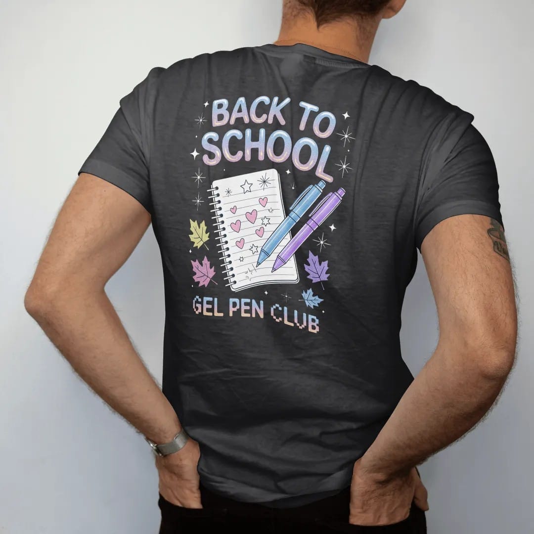 Man wearing a Black tee, seen from the back: glitter gel pens and a doodled notebook among fall leaves, with "BACK TO SCHOOL" and "GEL PEN CLUB" in liquid-chrome bubble letters and small pixel type, printed in glossy gunmetal chrome, cobalt, hot…