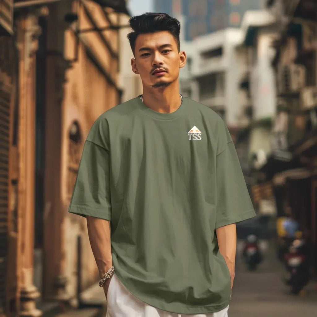 Man in a Moss tee on a city street, with the small Trailhead Standard logo on the left chest.
