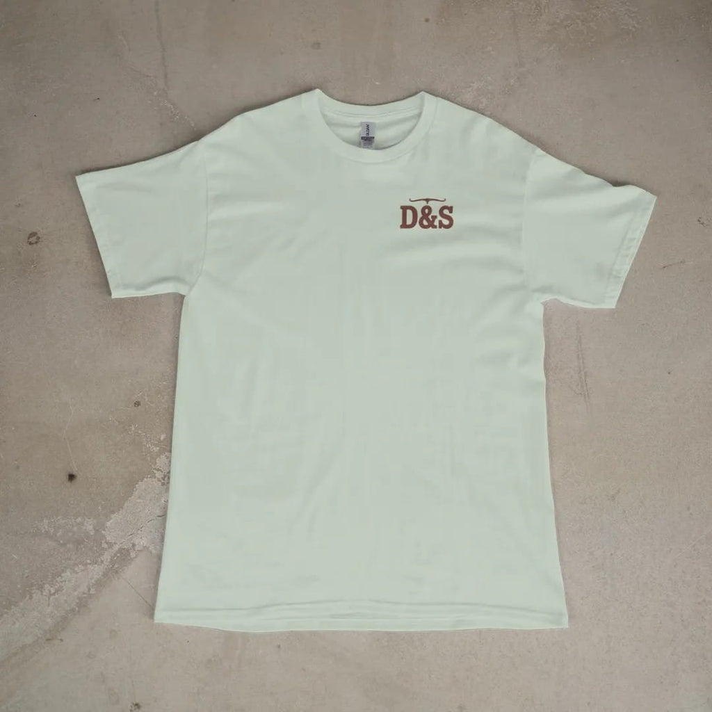 Front of a Bay tee laid flat, with the small Dust & Spur logo on the left chest.