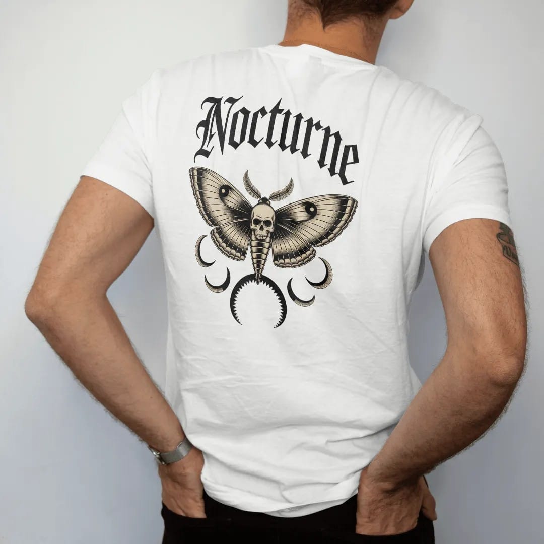 Man wearing a White tee, seen from the back: back print: death's-head hawkmoth with open wings and a skull marking on its back, crescent moons around it, detailed Victorian engraving with crosshatching, "NOCTURNE" arched above in ornate gothic…