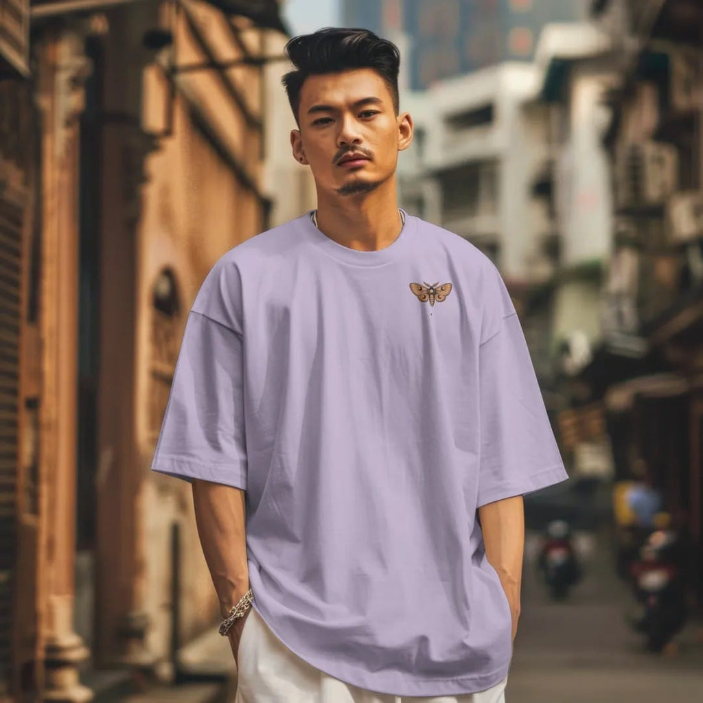 Man in a Orchid tee on a city street, with the small Nocturne logo on the left chest.