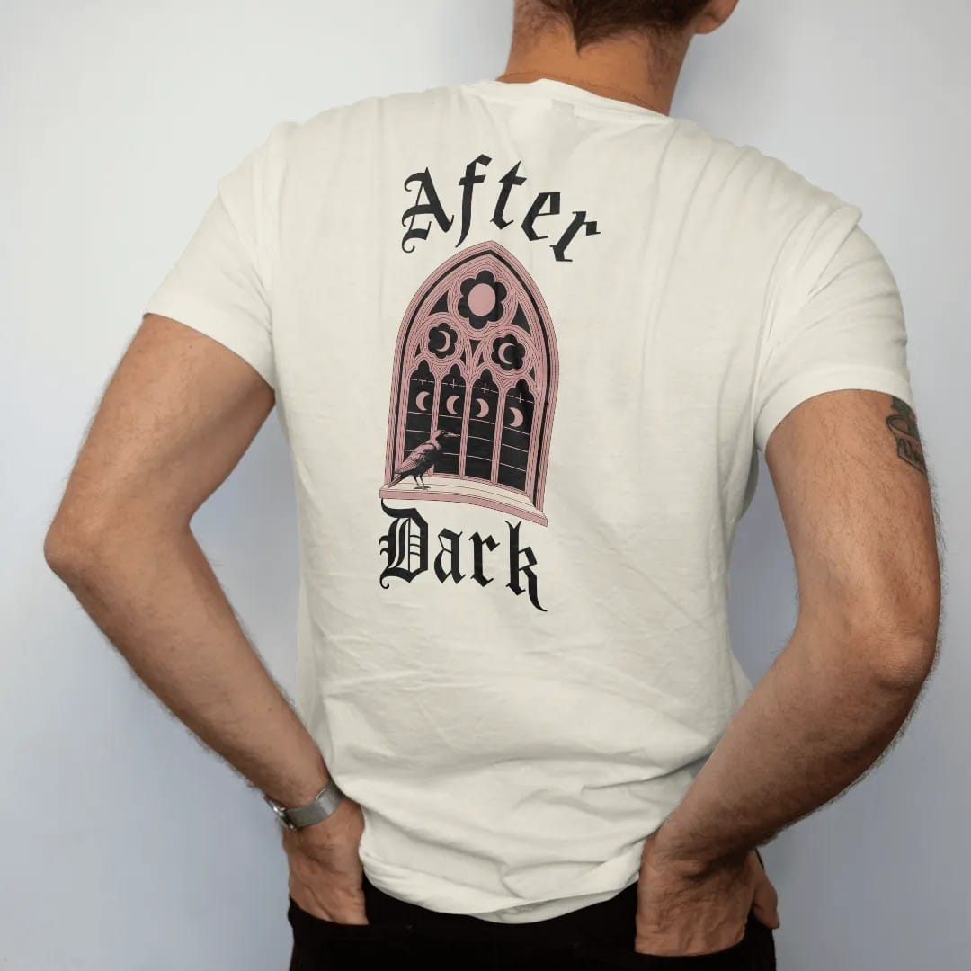 Man wearing a Ivory tee, seen from the back: back print: gothic cathedral rose window with moon phases in its panes and a raven on the sill, fine engraving style, "AFTER" above in elegant high-contrast serif caps, "DARK" below in ornate gothic…