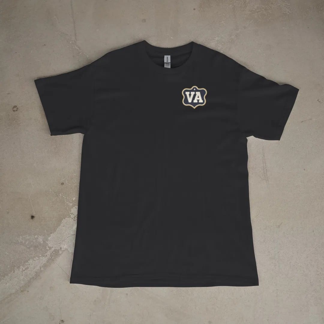 Front of a Black tee laid flat, with the small Varsity Archive logo on the left chest.